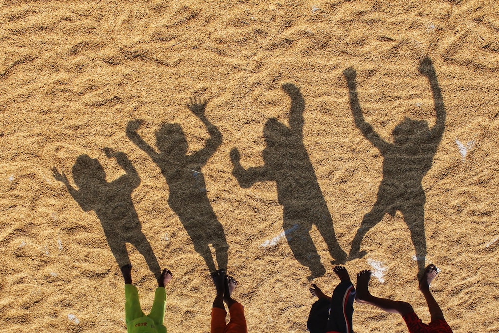 a group of people standing on top of a sandy beach