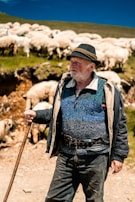Close-up of weathered hands gripping a shepherd’s staff, symbolizing strength and guidance.