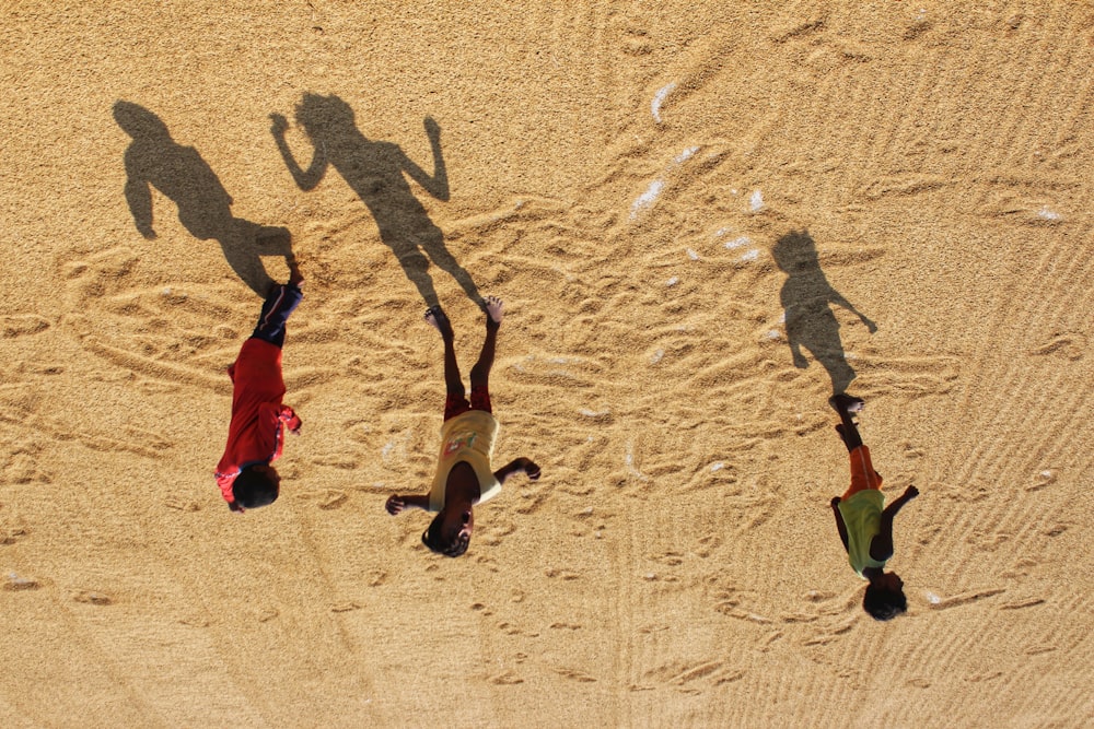 a group of people standing on top of a sandy beach