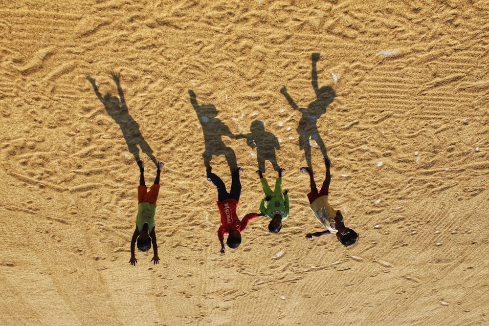 a group of people standing on top of a sandy beach