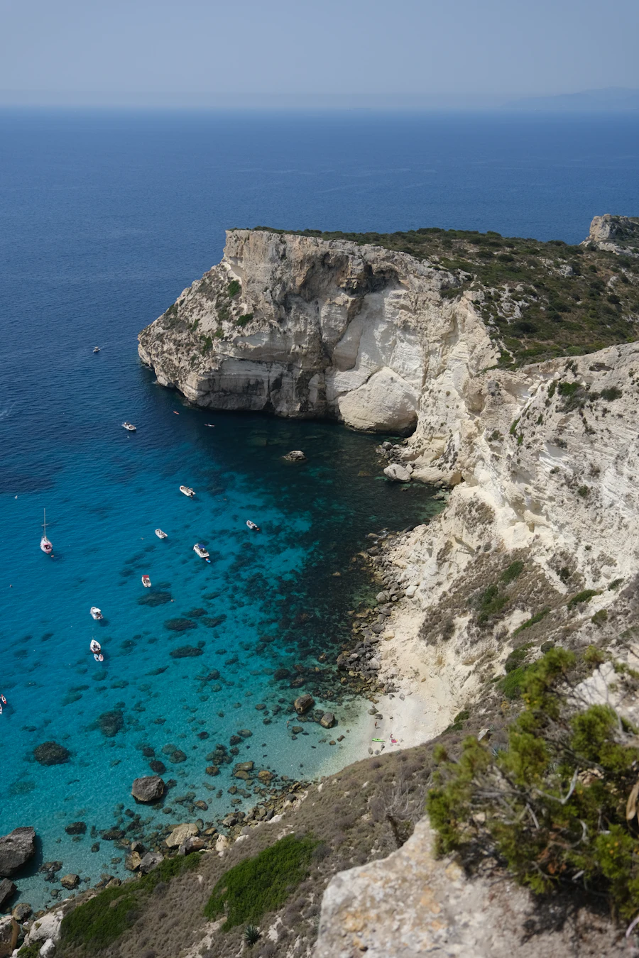 Barche ormeggiate sotto una scogliera