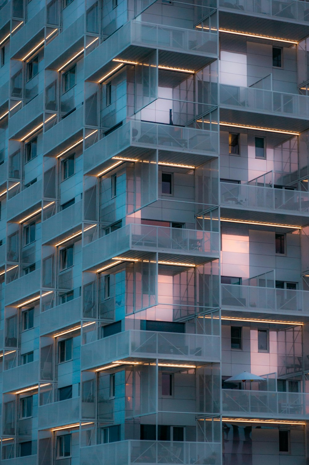 a tall building with balconies lit up at night