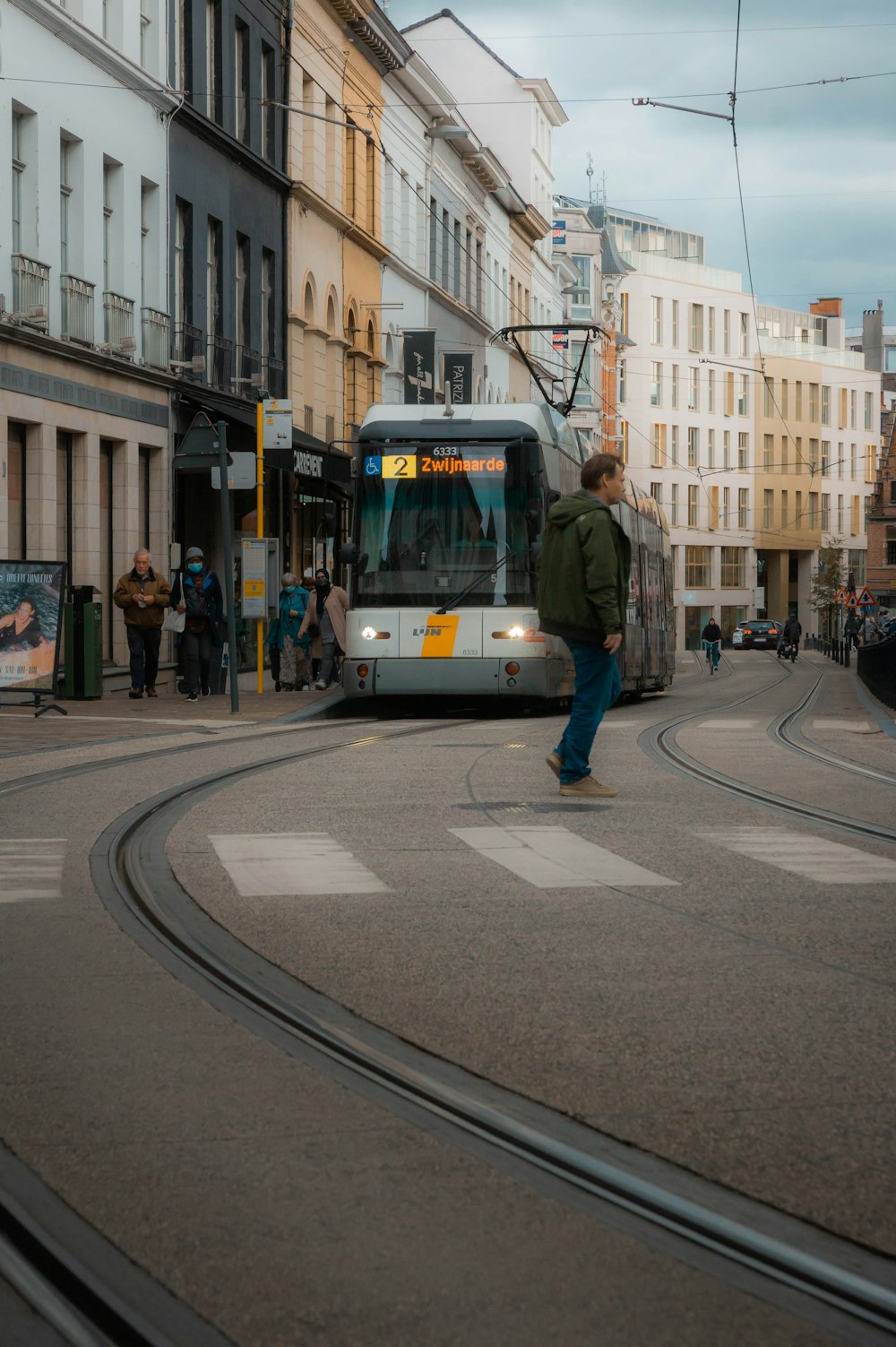 a man standing on the side of a street next to a train