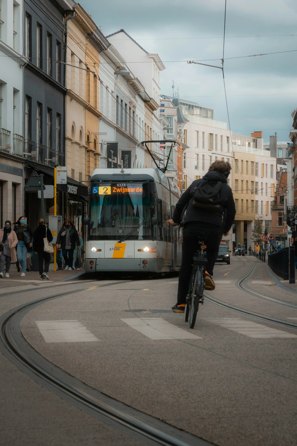 a man riding a bike down a street next to a bus