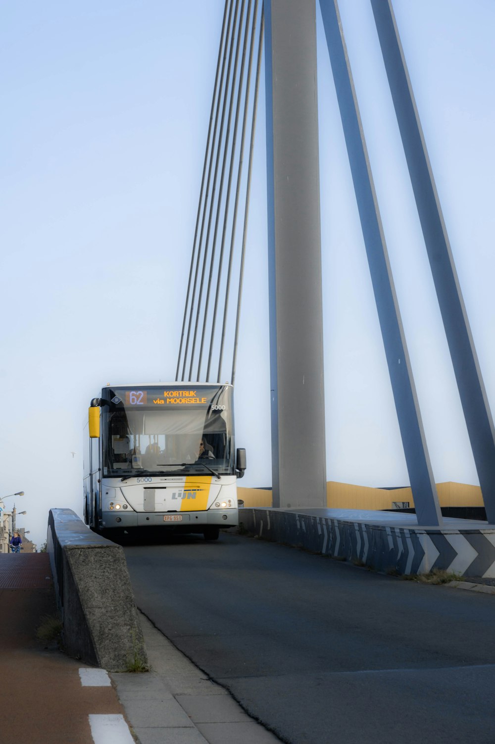 a bus driving over a bridge on a clear day