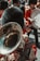 A vibrant marching band with musicians wearing red uniforms and black bearskin hats. One musician is prominently playing a large brass instrument, possibly a tuba or sousaphone. The scene is full of movement and energy, capturing the lively atmosphere of the parade.
