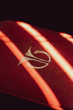 Close-up of a red care package badge glowing against a dark background.
