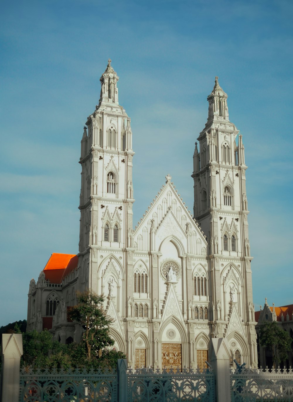 a large white church with two towers and a gate