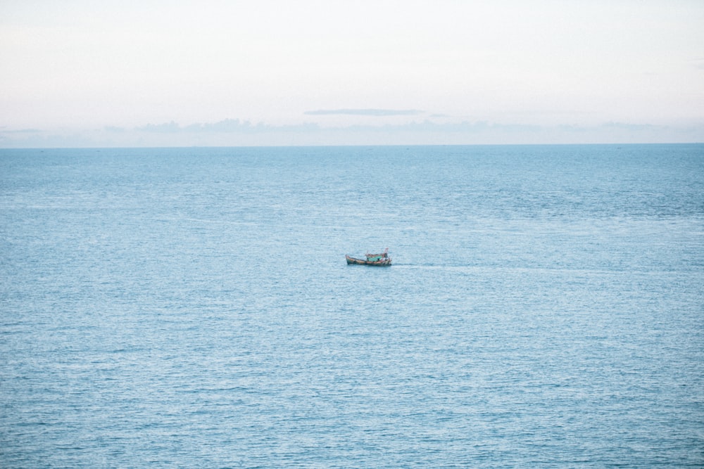 a small boat floating on top of a large body of water