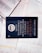 A dark-colored book titled 'De Volta ao Mosteiro' by James C. Hunter is lying on top of several open books with pages of text visible. The book cover features gold and white text along with an emblem or logo in white.