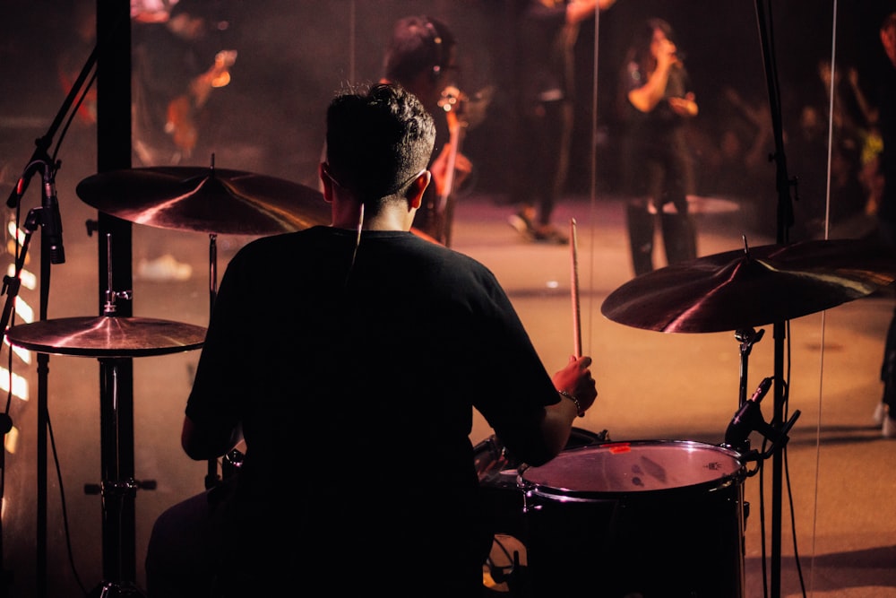 a man sitting in front of a drum set