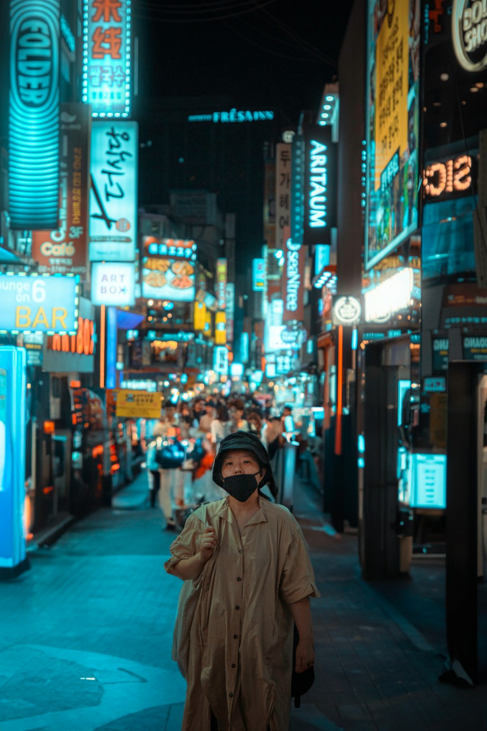 a man walking down a city street at night