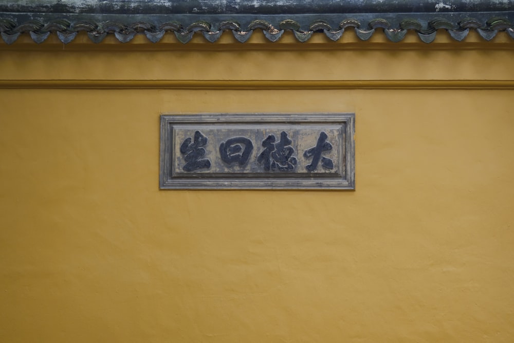 a sign on a yellow wall that says go