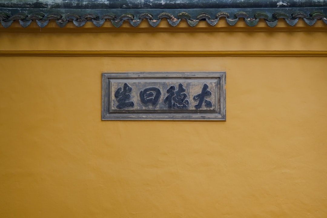 a sign on a yellow wall that says go,