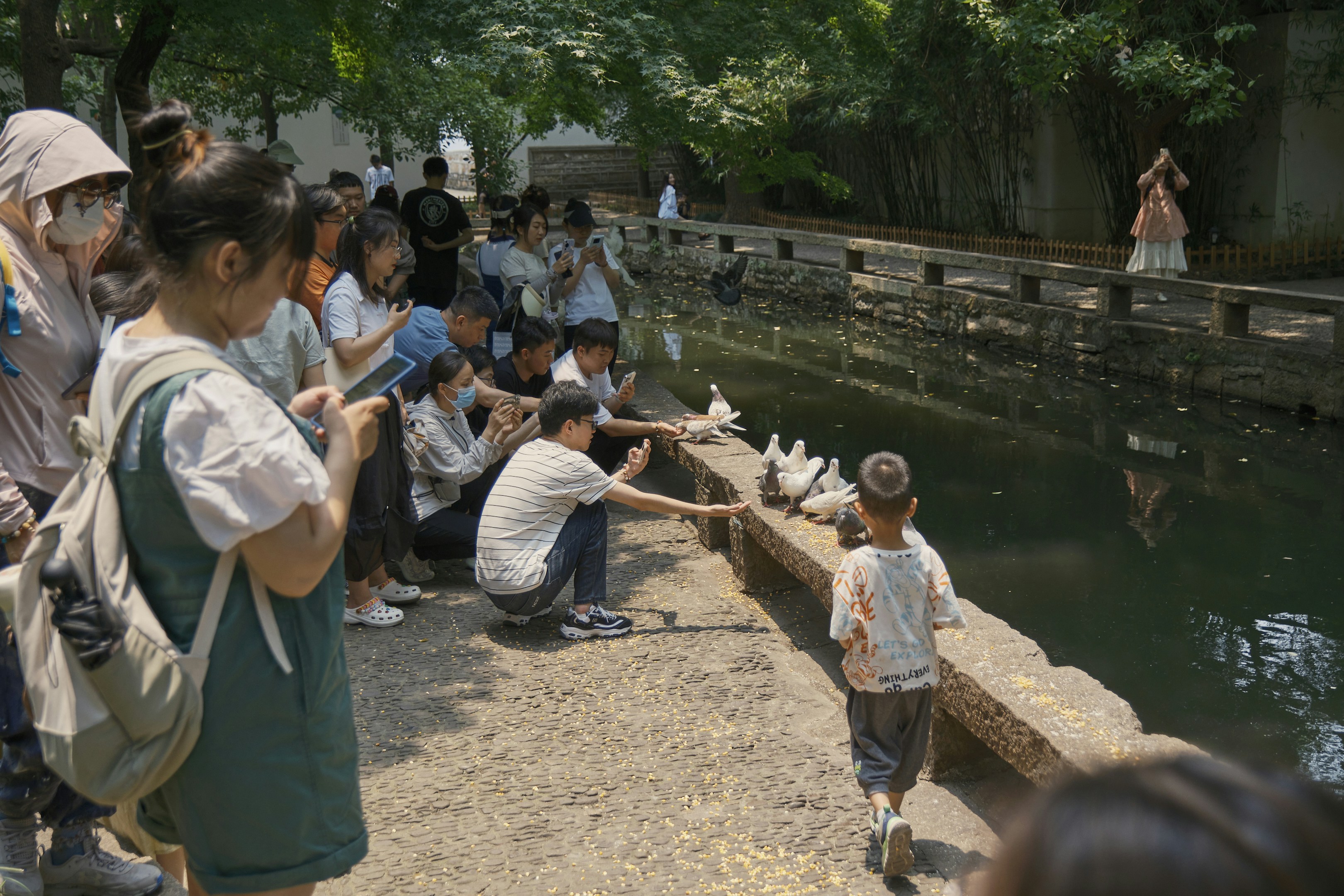 a group of people standing next to a body of water