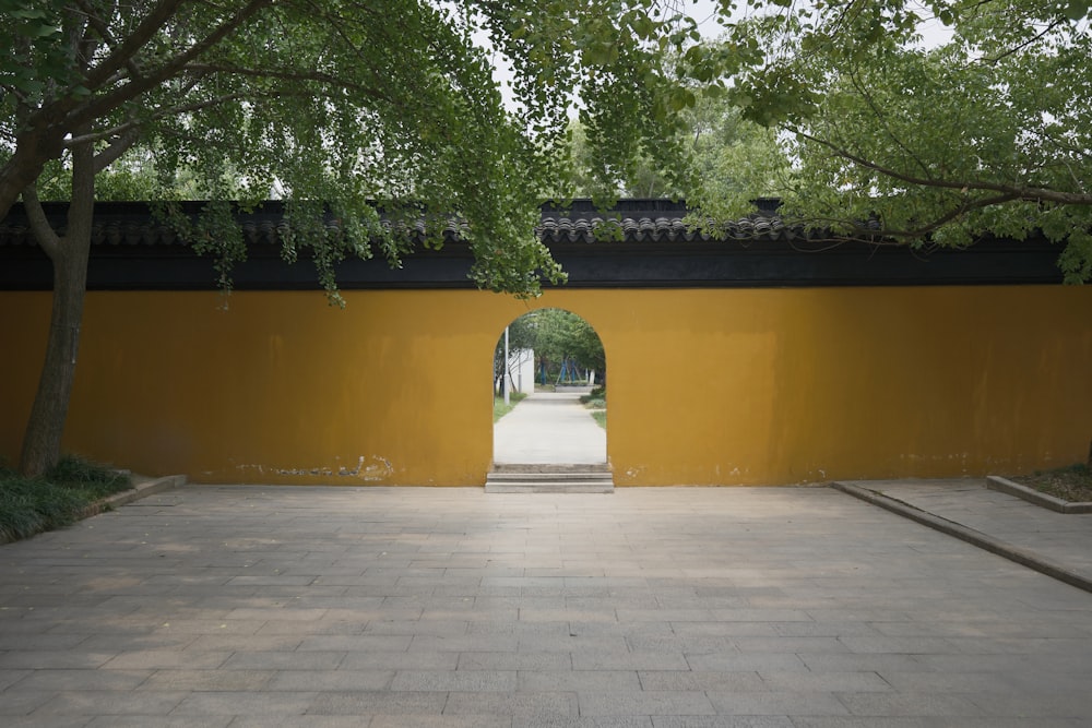 a yellow wall with a walkway leading to it