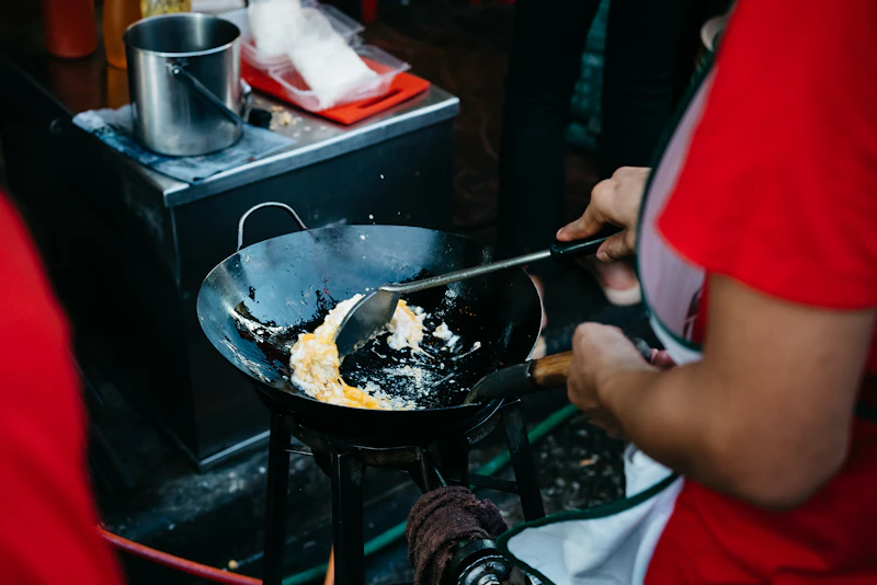 Pad thai sizzling in a hot wok at a Bangkok street-food stall