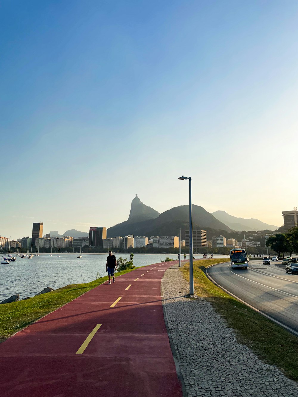 a person walking down a path next to a body of water