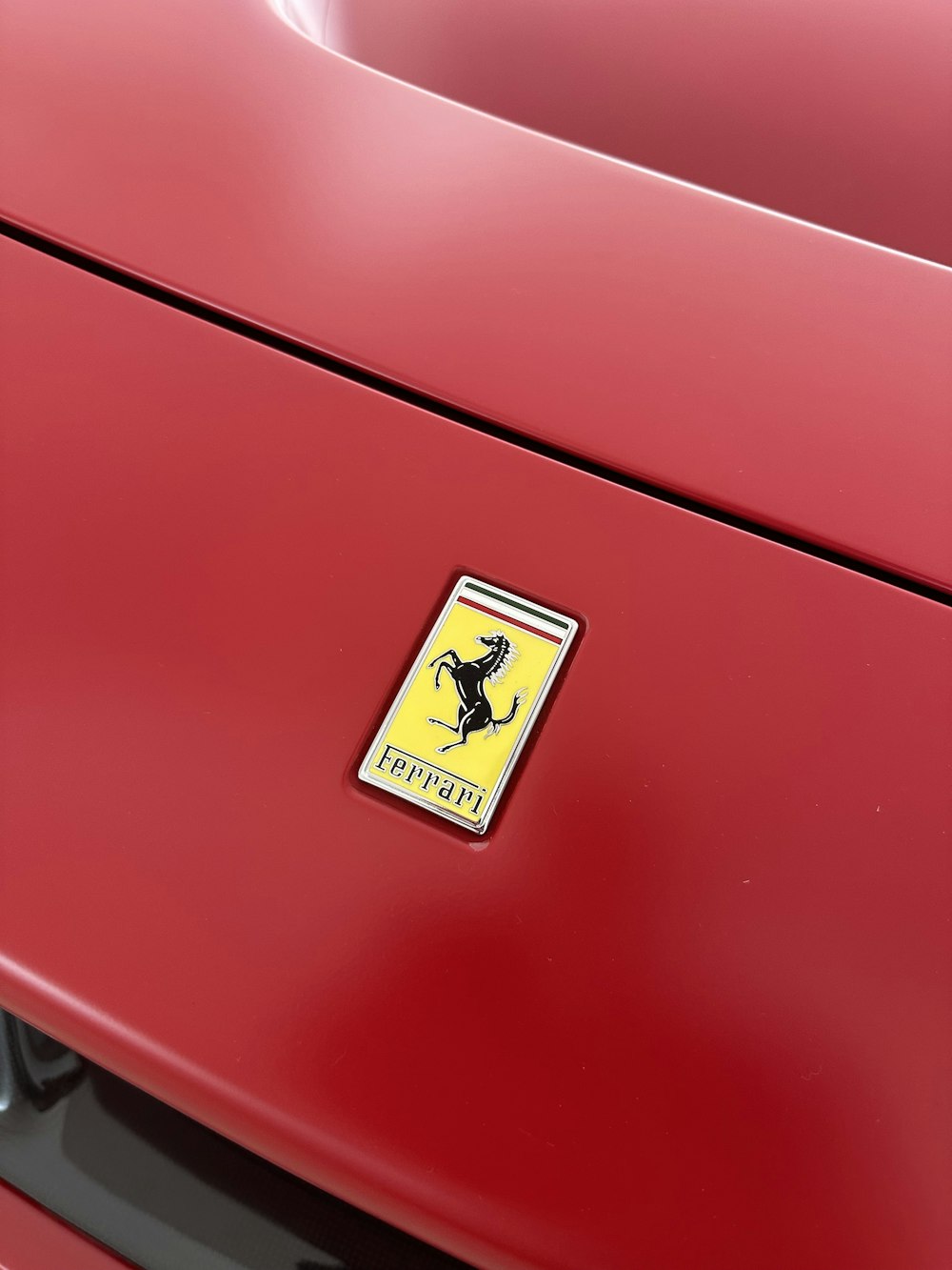 Un primo piano di un'auto rossa con un emblema giallo