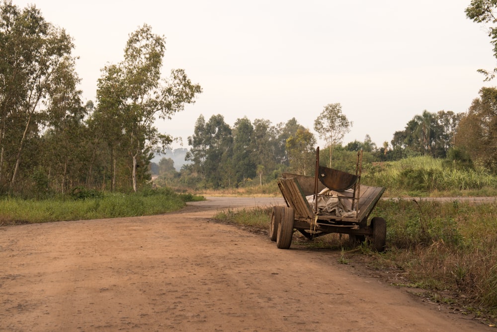 an old tractor sitting on the side of a dirt road