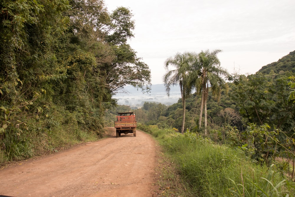 a truck is driving down a dirt road