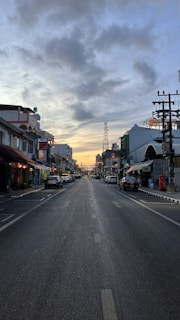 A cinematic still of a quiet street at dusk, shadows stretching long and colors muted