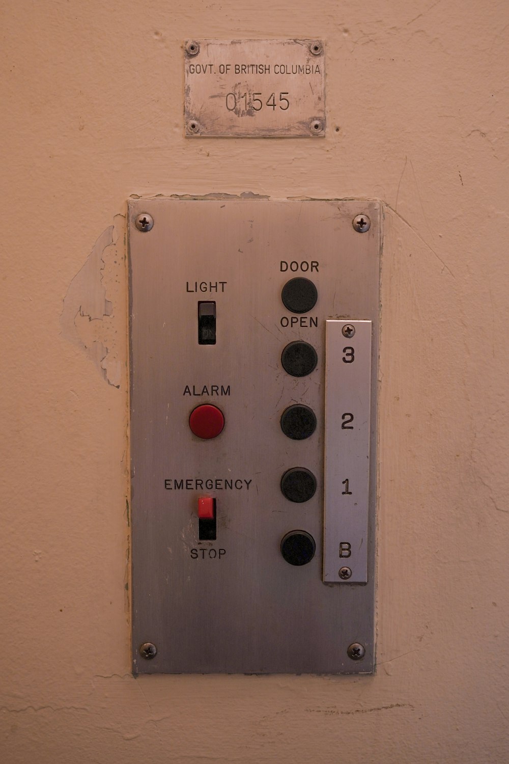 a light switch on a white wall with a red light