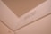 An interior corner of a room features a beige wall with a visible weight capacity indication marked 'MAX CAP - 1200 LBS -'. The surface appears smooth and painted, with lighting giving it a warm hue.