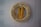 A beige life preserver ring with black text hangs on a light gray brick wall. Attached to the preserver is a coiled yellow rope. The text reads 'THERESA JEAN APTS. EMERGENCY ONLY.'