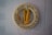 A beige life preserver ring with black text hangs on a light gray brick wall. Attached to the preserver is a coiled yellow rope. The text reads 'THERESA JEAN APTS. EMERGENCY ONLY.'