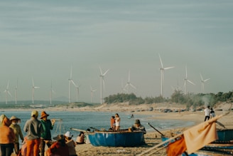 a group of people standing on top of a sandy beach