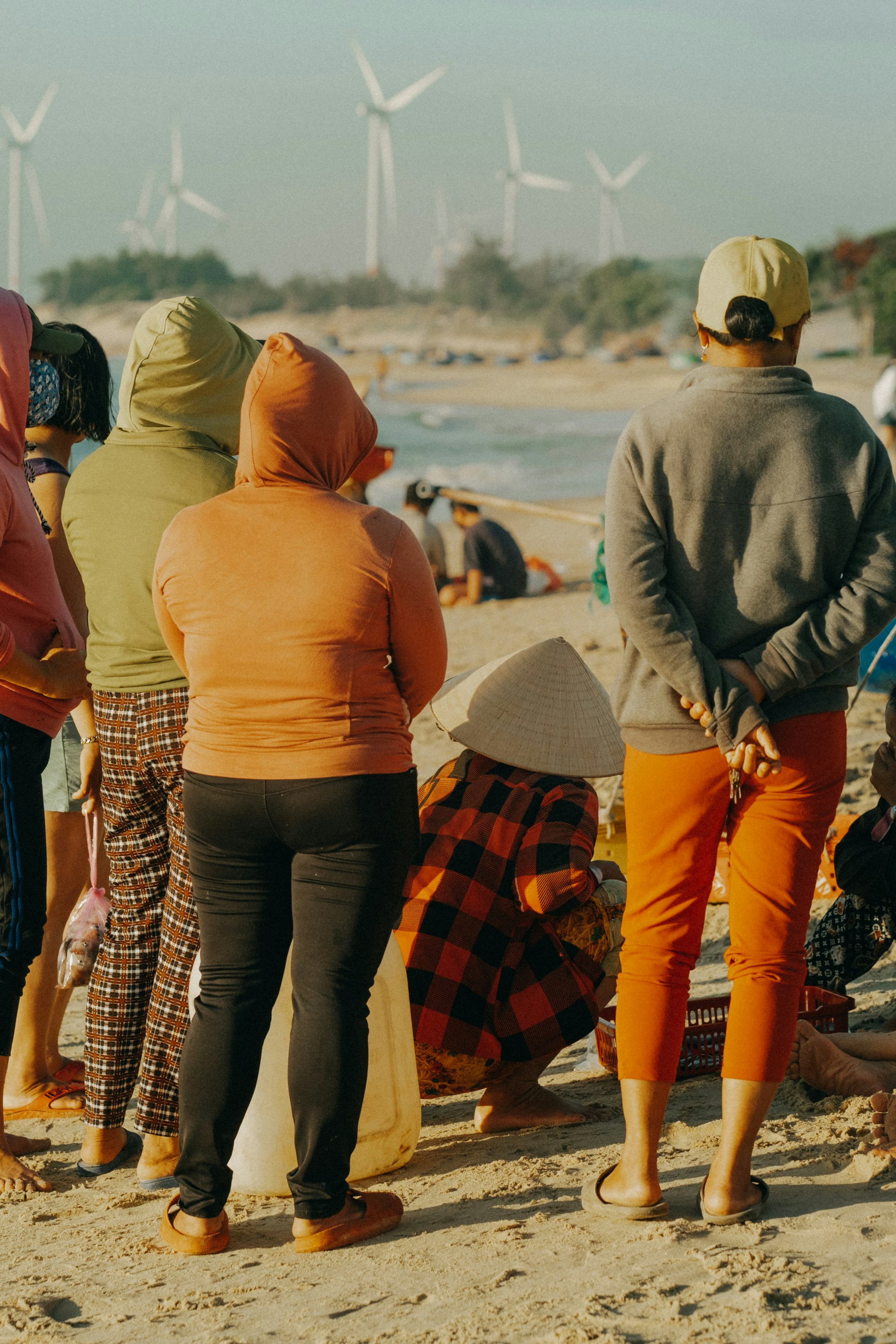 A group of people standing on top of a sandy beach photo – Free Beach ...