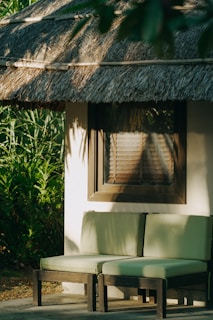 Insulated outdoor cushioned chair placed on a sunny patio with greenery in the background.