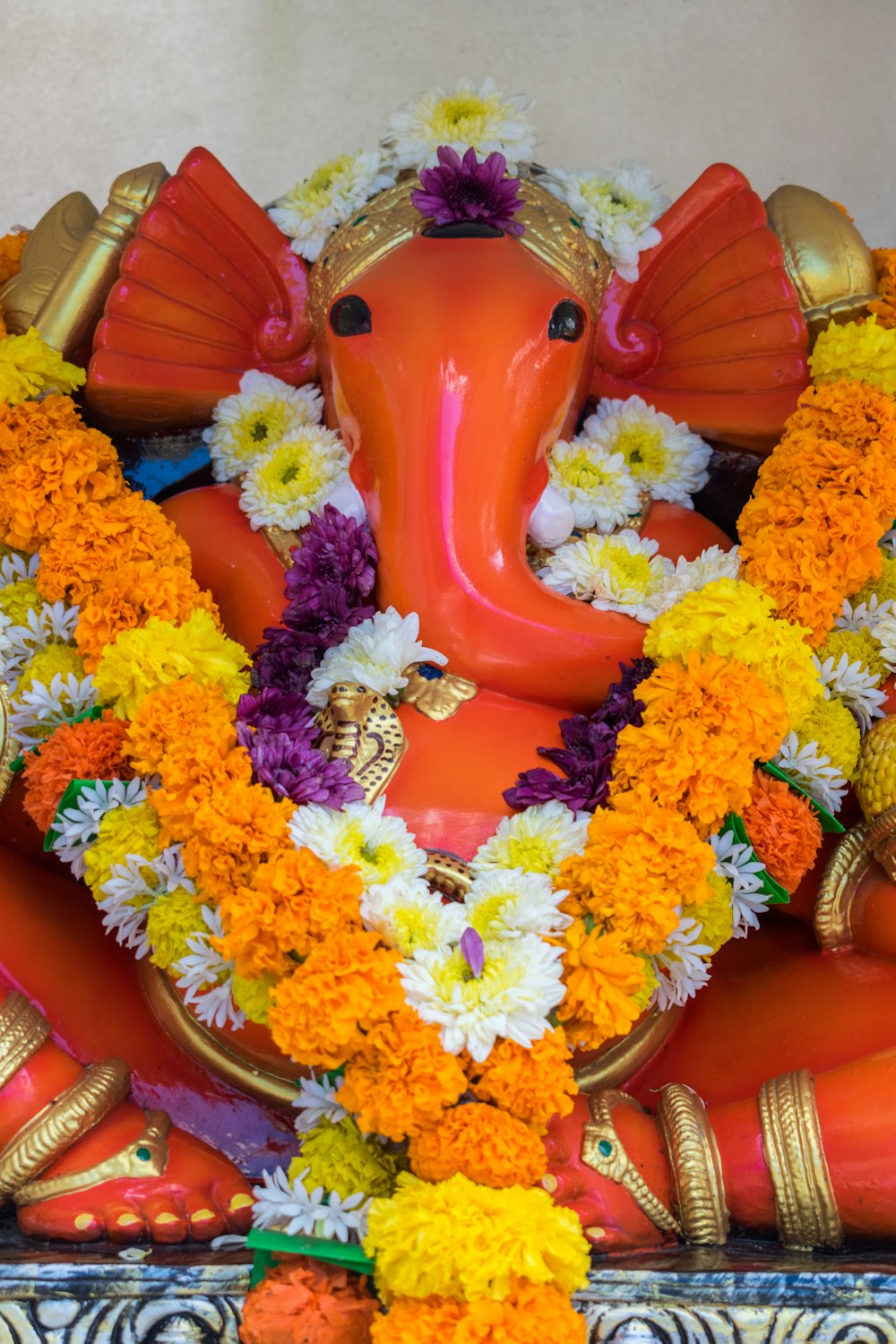 a statue of an elephant with flowers around it