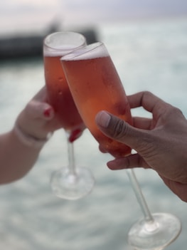 a toast of wine glasses on the beach