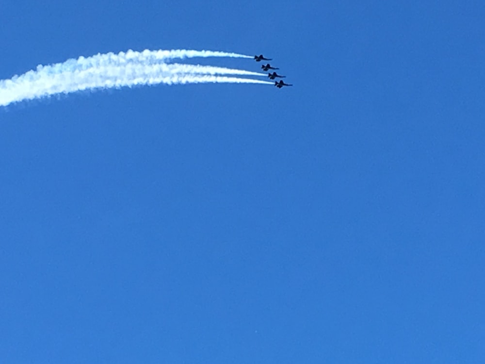 a group of jets flying through a blue sky