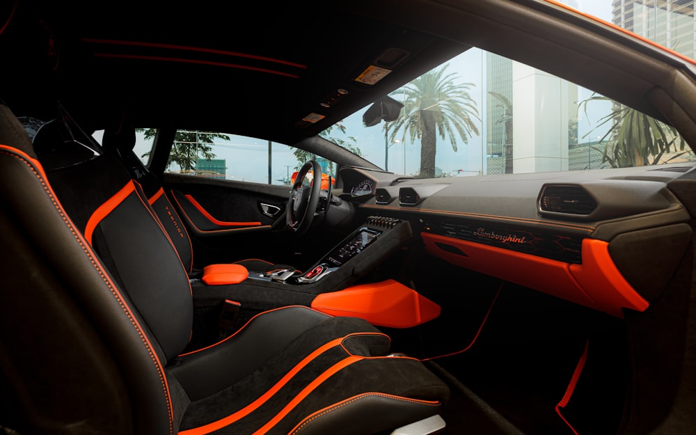 the interior of a sports car with orange stitching