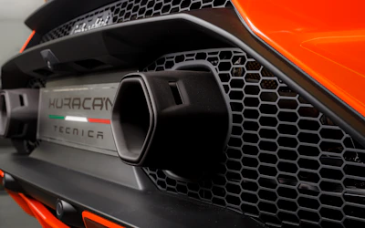 Side view of a custom exhaust system being fitted on a high-performance car.