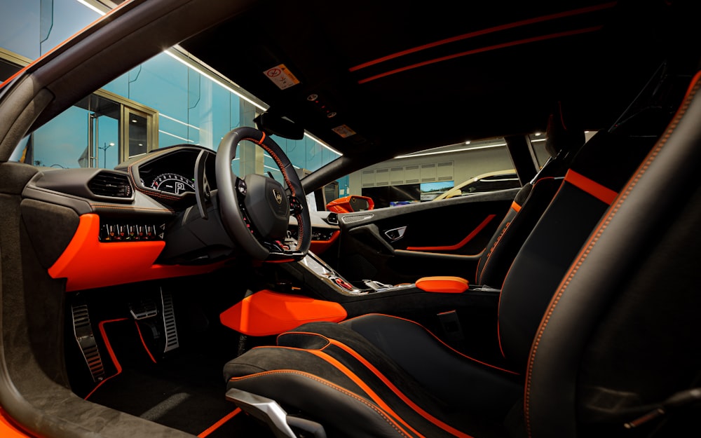 the interior of a sports car with orange trim