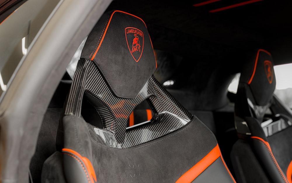 the interior of a sports car with orange stitching