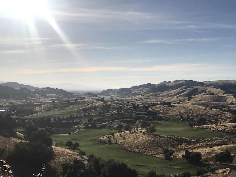 a scenic view of a golf course in the hills