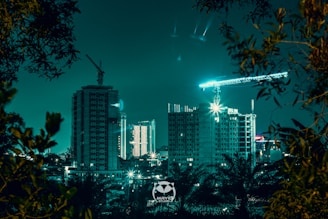 Nighttime cityscape with illuminated construction sites showcasing advanced robotic machinery.