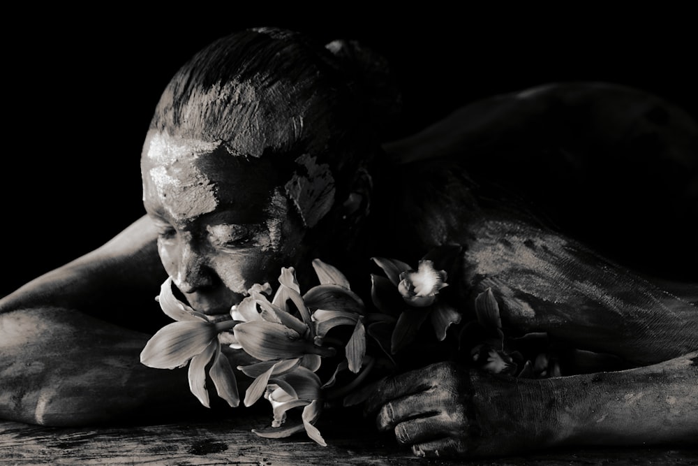 a black and white photo of a man with flowers in his hands