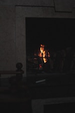 A cozy hearth glowing softly in a dimly lit room, symbolizing warmth and comfort.