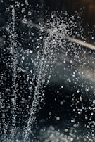 Close-up of ultra-fine water droplets produced by a low-pressure mist unit against a dark background.