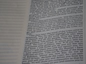 A close-up view of a page from a book with text printed in two columns. The text is clear and in English, featuring both narrative and dialogues. There are dotted lines on the left side of the page, possibly for writing notes.