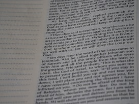 A close-up view of a page from a book with text printed in two columns. The text is clear and in English, featuring both narrative and dialogues. There are dotted lines on the left side of the page, possibly for writing notes.