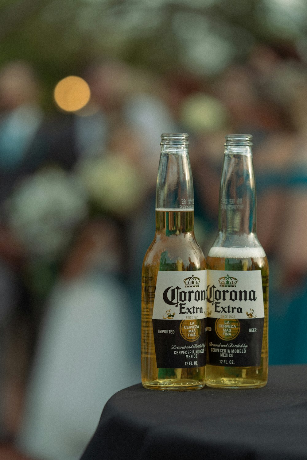 two bottles of corona beer sitting on top of a table