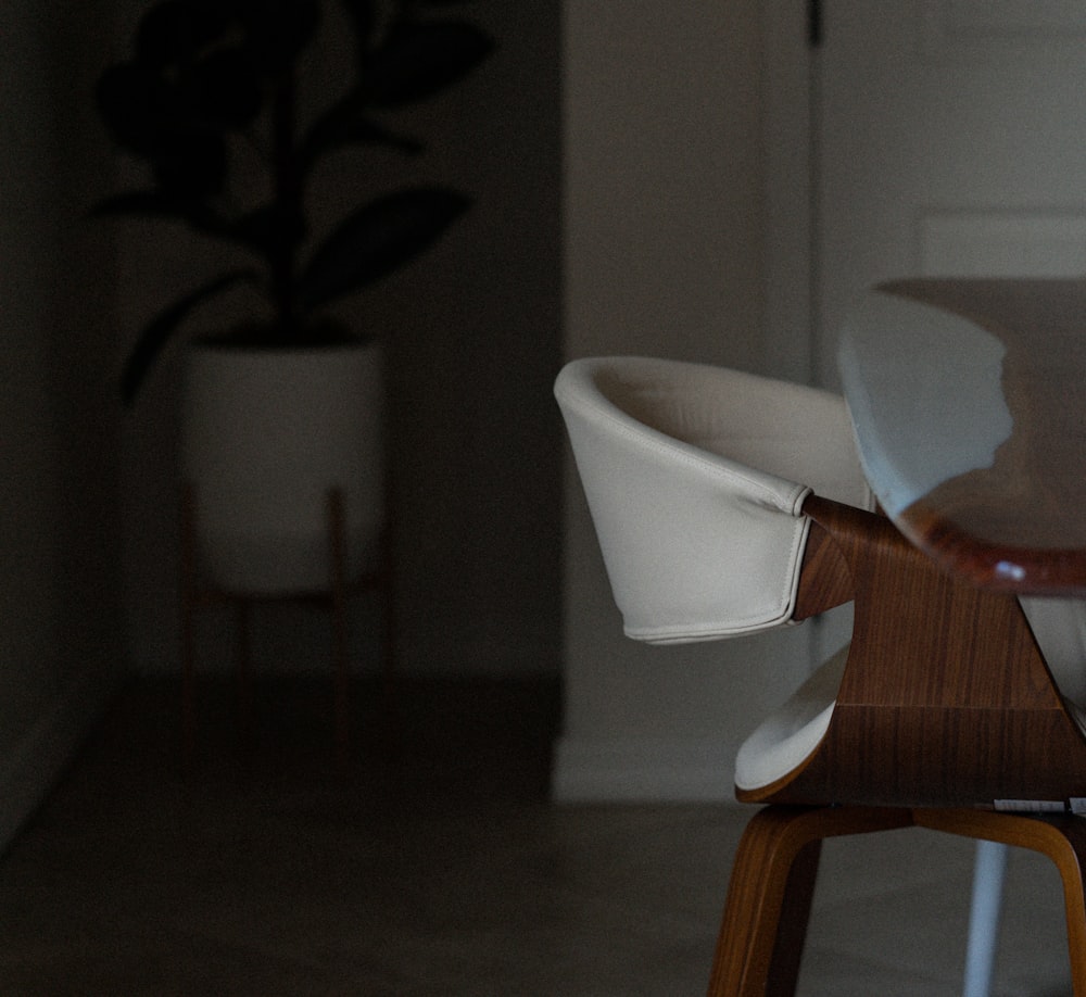 a close up of a chair with a plant in the background