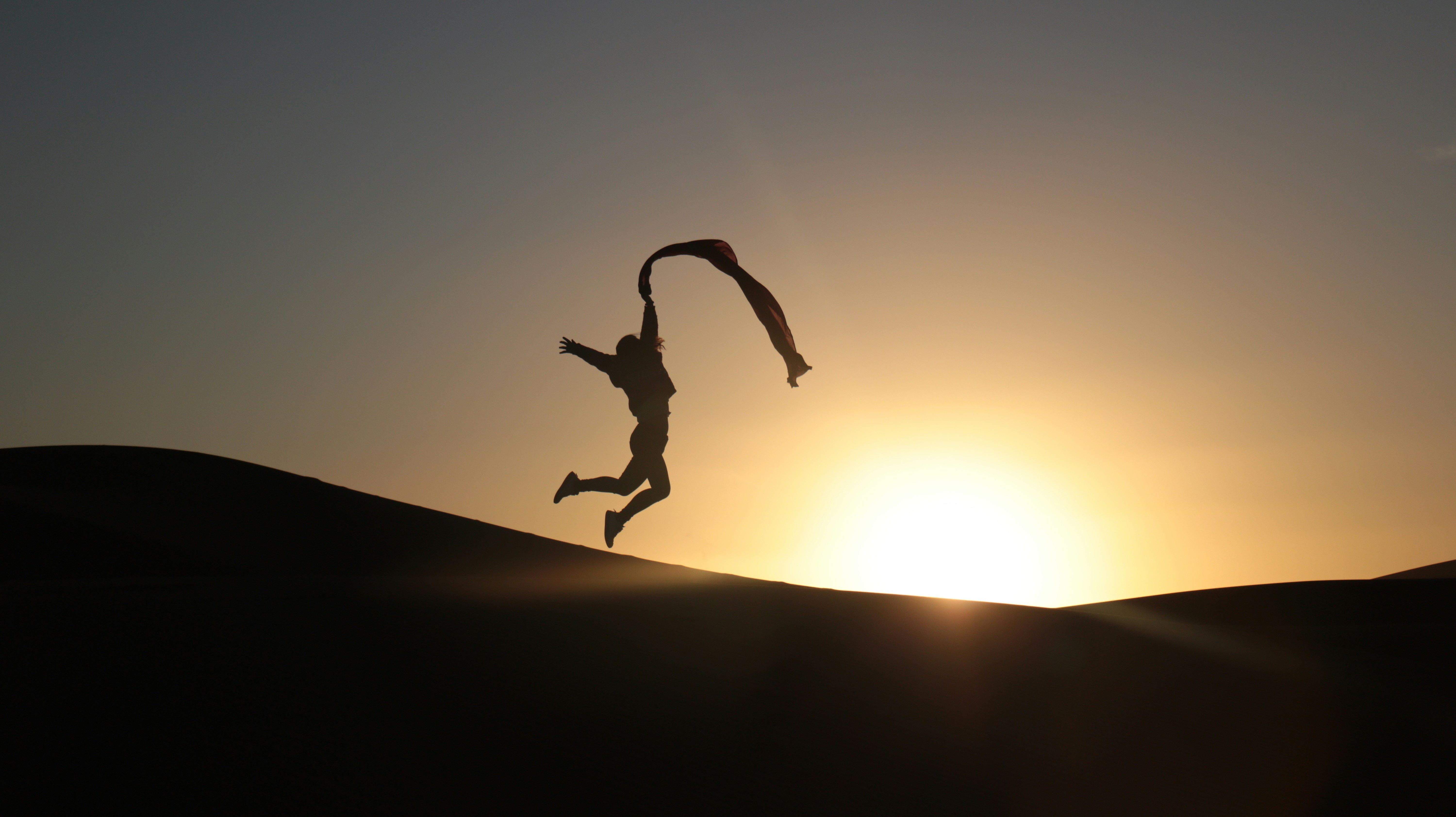 A person jumping in the air with a kite